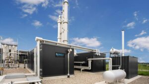 A modern industrial gas processing facility with tanks and pipework under a clear blue sky.
