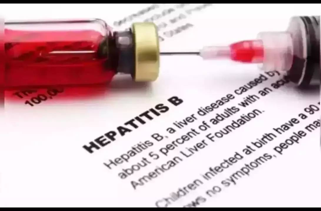 A vial and syringe over a blurred document discussing Hepatitis B, highlighting health concerns.