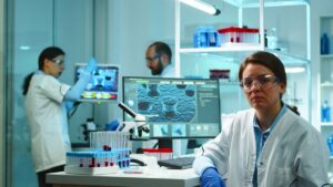 Three scientists in a lab, analyzing data and samples with advanced technology and equipment.